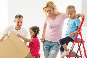 young family who does repair at home, daughter sits fireplace beautiful mother and smiling father stand and measure high of their daughter