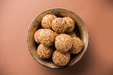Tilgul Laddu or Til Gul balls for makar sankranti, it's a healthy food made using sesame, crushed peanuts and jaggery. served in a bowl. selective focus showing details.