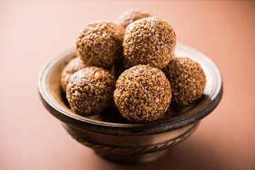Tilgul Laddu or Til Gul balls for makar sankranti, it's a healthy food made using sesame, crushed peanuts and jaggery. served in a bowl. selective focus showing details.