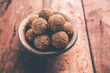 Tilgul Laddu or Til Gul balls for makar sankranti, it's a healthy food made using sesame, crushed peanuts and jaggery. served in a bowl. selective focus showing details.