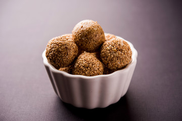Tilgul Laddu or Til Gul balls for makar sankranti, it's a healthy food made using sesame, crushed peanuts and jaggery. served in a bowl. selective focus showing details.
