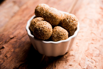 Tilgul Laddu or Til Gul balls for makar sankranti, it's a healthy food made using sesame, crushed peanuts and jaggery. served in a bowl. selective focus showing details.