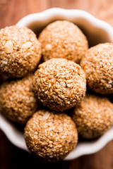 Tilgul Laddu or Til Gul balls for makar sankranti, it's a healthy food made using sesame, crushed peanuts and jaggery. served in a bowl. selective focus showing details.