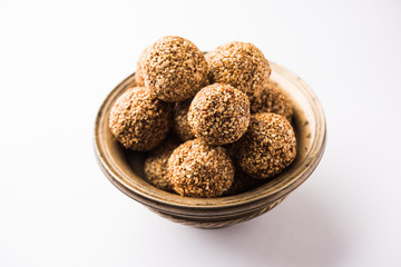 Tilgul Laddu or Til Gul balls for makar sankranti, it's a healthy food made using sesame, crushed peanuts and jaggery. served in a bowl. selective focus showing details.