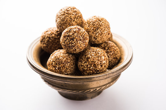 Tilgul Laddu or Til Gul balls for makar sankranti, it's a healthy food made using sesame, crushed peanuts and jaggery. served in a bowl. selective focus showing details.