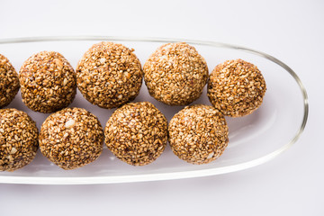 Tilgul Laddu or Til Gul balls for makar sankranti, it's a healthy food made using sesame, crushed peanuts and jaggery. served in a bowl. selective focus showing details.