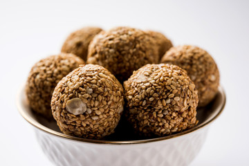 Tilgul Laddu or Til Gul balls for makar sankranti, it's a healthy food made using sesame, crushed peanuts and jaggery. served in a bowl. selective focus showing details.