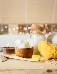 Obraz na płótnie Canvas Using natural material products in home, different eco friendly cosmetic products in bathroom. Minimizing ecological footprint concept. Bamboo bath towel, biodegradable bamboo toothbrush, coconut oil.