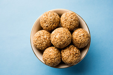 Tilgul Laddu or Til Gul balls for makar sankranti, it's a healthy food made using sesame, crushed peanuts and jaggery. served in a bowl. selective focus showing details.