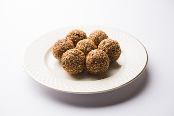 Tilgul Laddu or Til Gul balls for makar sankranti, it's a healthy food made using sesame, crushed peanuts and jaggery. served in a bowl. selective focus showing details.