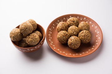 Tilgul Laddu or Til Gul balls for makar sankranti, it's a healthy food made using sesame, crushed peanuts and jaggery. served in a bowl. selective focus showing details.
