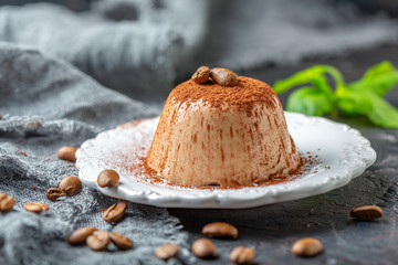 Coffee Panna cotta with cocoa powder on a plate.