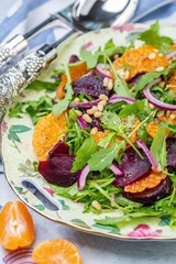 Fototapeta na wymiar Salad of arugula, baked beets and tangerines.