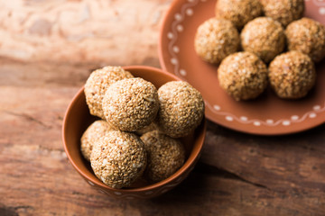 Tilgul Laddu or Til Gul balls for makar sankranti, it's a healthy food made using sesame, crushed peanuts and jaggery. served in a bowl. selective focus showing details.