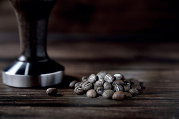 temper coffee beans on a brown wooden background blur