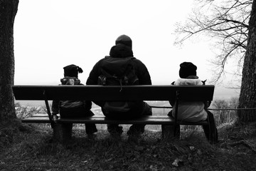 Naklejka na ściany i meble Vater und Söhne sitzen auf einer Bank