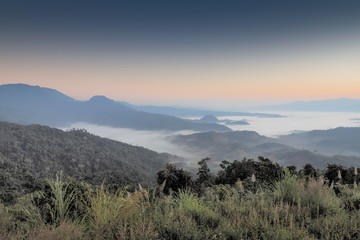Mountain view morning of the hill around with the ocean of mist with blue sky background, sunrise at Tham Sakoen View Point attraction on route 1148, Tham Sakoen National Park, Nan Province, Thailand.