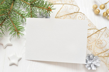 Empty white sheet of paper on a white Christmas background of fir branches and cones. Letter on xmas, mockup