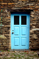 Rustic hand-hewn wood door set into a stone wall built from schist in Piodão, made of shale rocks stack, one of Portugal's schist villages in the Aldeias do Xisto.