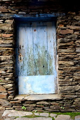 Rustic hand-hewn wood door set into a stone wall built from schist in Piodão, made of shale rocks stack, one of Portugal's schist villages in the Aldeias do Xisto.