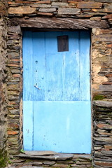 Rustic hand-hewn wood door set into a stone wall built from schist in Piodão, made of shale rocks stack, one of Portugal's schist villages in the Aldeias do Xisto.