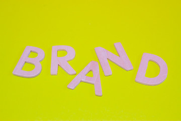 Wooden letters forming the word brand on green background