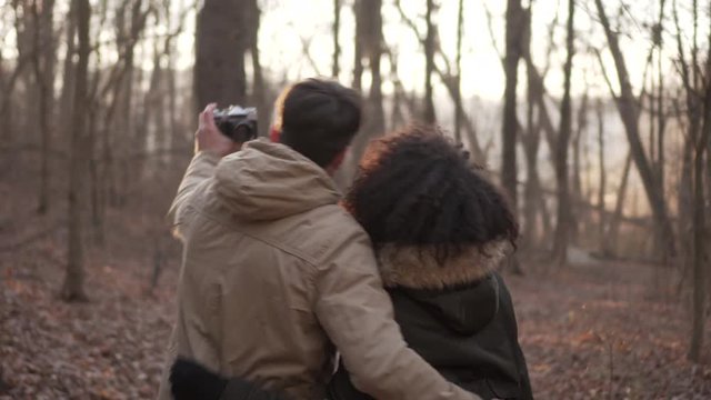 Couple taking self portrait using digital camera at forest