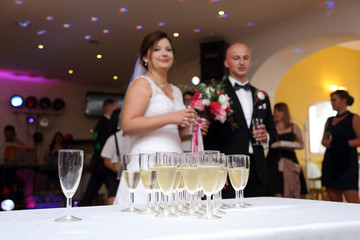 Kieliszki z szampanem na stole przed Młodą Parą, ślub, wesele.