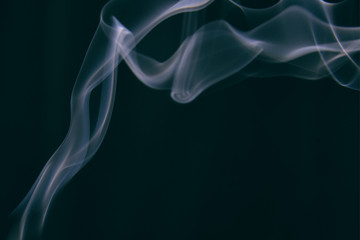 smoke wriggles around in different patterns on a black background.