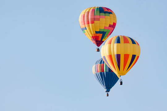 Multi colored hot air balloons flying over blue sky