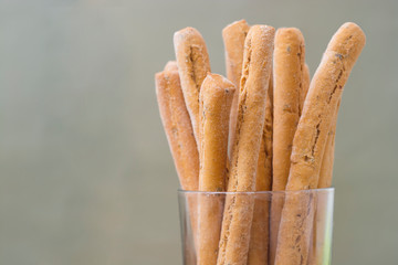 Grissini on wooden table. Traditional italian snack with herbs. Copy space.