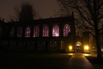 Outside view on a cold wet night of the stained glass windows of the All Saints Chapel at The University of the South in Sewanee, Tennessee.