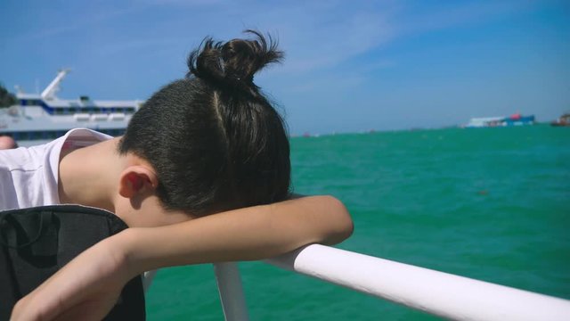 boy teenager suffers from motion sickness while on a boat trip. Fear of traveling or illness of the virus during a cruise holiday.