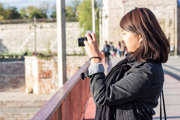Chinese Girl Standing on the Bridge and Taking Picture With Her Photo Camera