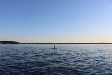 Obraz na płótnie Canvas Woman on a paddle board on a lake