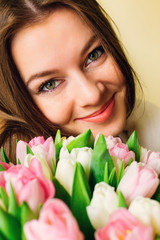 Beautiful stylish girl with pink tulips on white background. sensual looking eyes of young woman and flowers. natural beauty. skin care. spring bride bouquet. happy women's day.