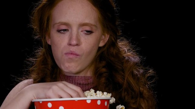 redhead woman can not stop eating popcorn