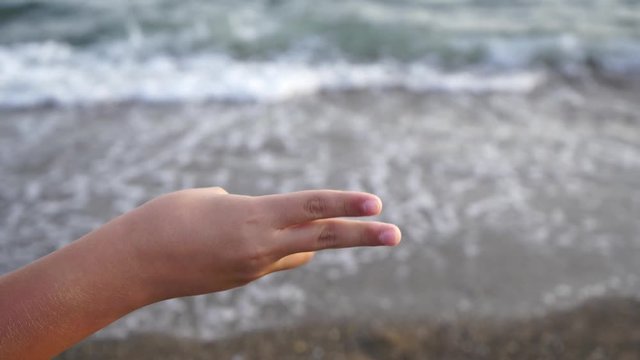 Closeup view of white tanned kid's hand counting with finger from one two fiver and showing thumb up cheerfully. Real time 4k video footage.