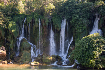 Fototapeta na wymiar Popular with tourists Kravica waterfall is a large tufa cascade on the Trebižat River, in the karstic heartland of Herzegovina in Bosnia and Herzegovina
