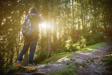 A traveler-photographer observes the sunset over the forest and