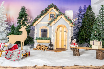 New Year's house with deer and trees, a winter house in the forest, a fairy tale, miracles, sledges.
