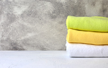 Stack of cotton towels in a bathroom with decorative stucco background. Place for a copy space.