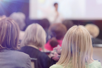 Beautiful business woman with microphone in her hand speaking at the  conference or seminar.