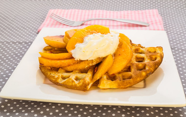 Peaches and Whipped Cream on Golden Brown Waffles