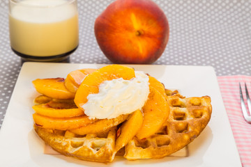 Peaches and Whipped Cream on Waffle with Glass of Cold Milk
