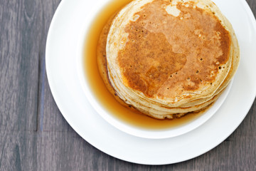 Maple syrup on gold tasty pancakes, top view