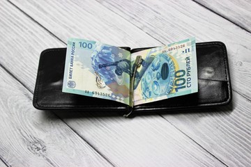 Black purse with a hundred-ruble bill 