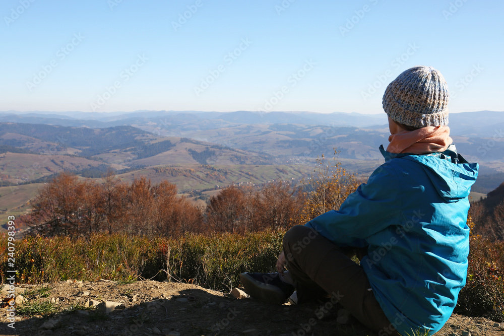 Wall mural woman in warm clothes enjoying mountain landscape