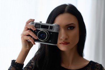 Woman taking photos with old vintage photo camera