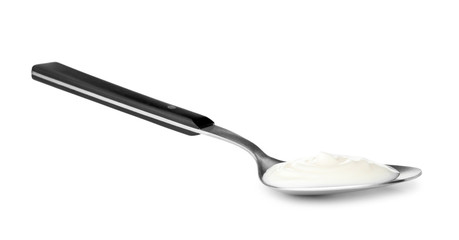 Metal spoon with sour cream on white background